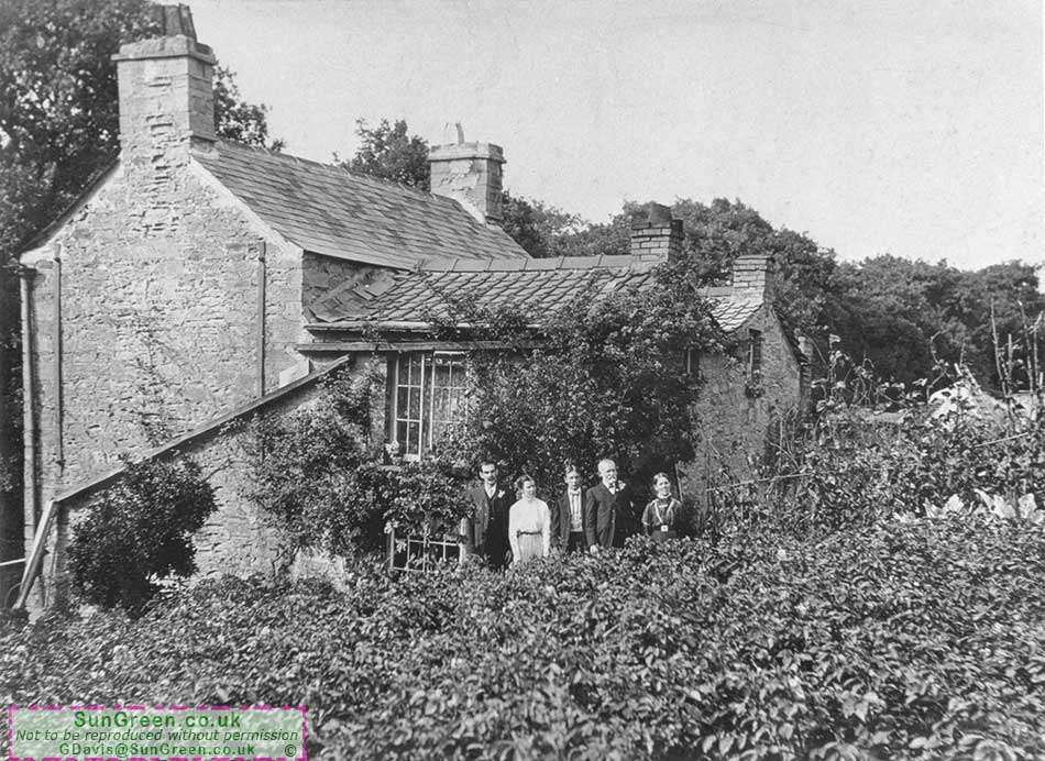 A photo of a family outside Rose Cottage, Ellwood.
